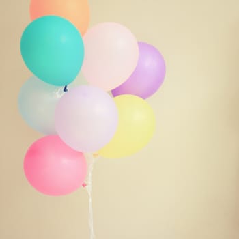 Colorful festive balloons on wall with retro filter effect 