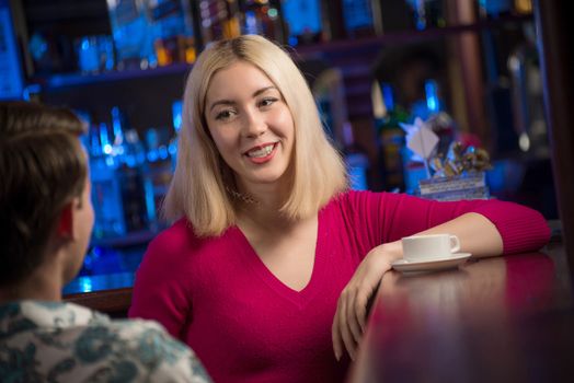 portrait of a nice woman at the bar, talking with a man at the bar date