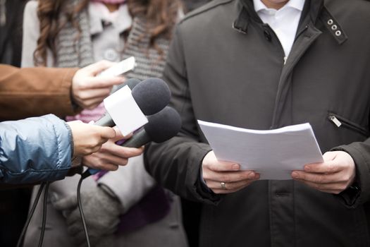 Interview with media microphone held in front of businessman, spokesman or politician