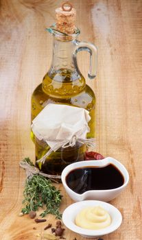 Ingredient for Cooking Salad Sauce with Olive Oil, Spices, Herbs and Mayonnaise closeup on Wooden background