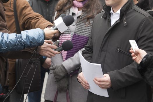 Interview with media microphone held in front of businessman, spokesman or politician