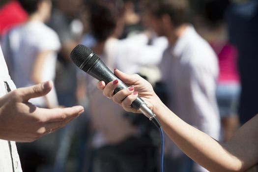 A journalist is making a interview with a microphone