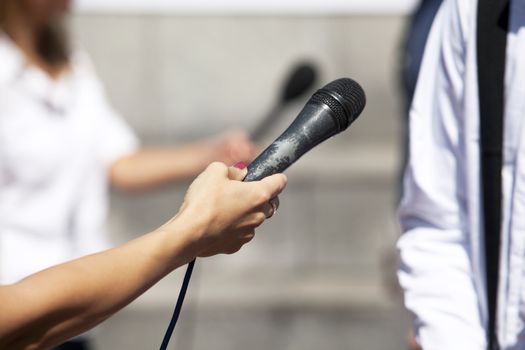 A journalist is making a interview with a microphone