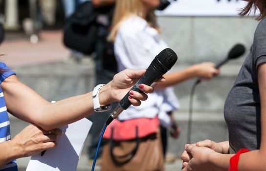 A journalist is making a interview with a microphone