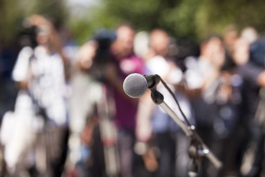 Microphone in focus against blurred audience