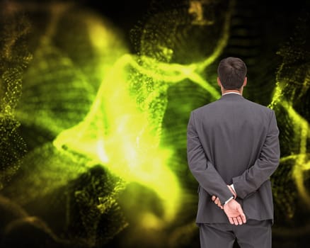 Composite image of businessman standing with hands behind back on black background with green glowing pattern