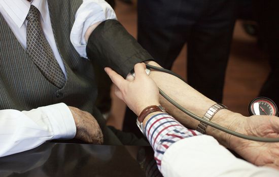 Doctor/nurse checking senior men blood pressure