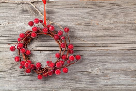 Christmas wreath from red berries on wooden background
