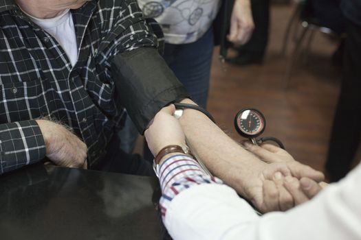 Doctor/nurse checking senior men blood pressure