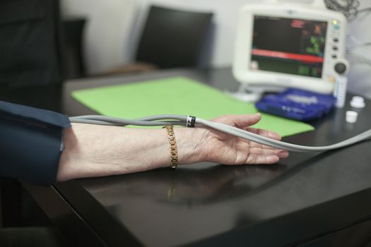 Doctor/nurse checking senior woman blood pressure