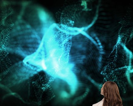 Composite image of brunette businesswoman looking up on black background with blue glowing pattern