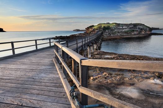 Sunrise at Bare Island Australia.  The island is accessible to public at all times but the old fort, now museum is open to public during certain hours.  The  island is popular for fisherman, divers and tourists because of its diverse marine life, caverns and reefs.  Focus to foreground.  