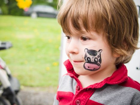 Boy with a cow drawing on his face