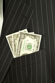 Dollars banknotes in a pocket of a businessman suit.