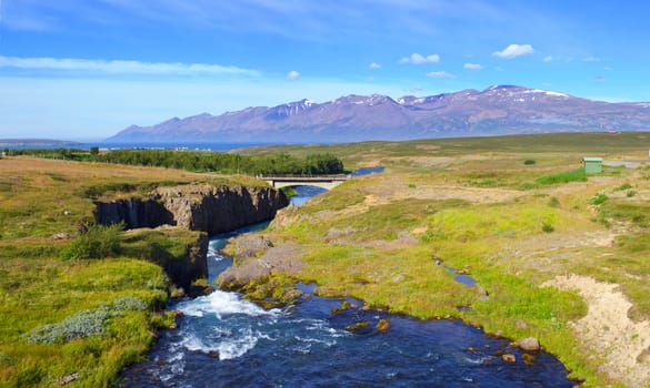 Beautiful landscape. Iceland. Mountain, river, forest, blue sky. Panorama