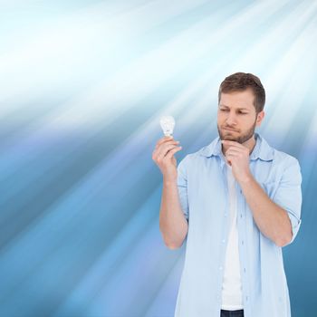 Composite image of sceptical model holding a bulb 