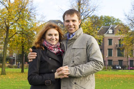 Outdoor happy couple in love posing in Museum Plein, autumn Amsterdam