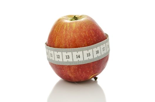 Apple wrapped with measuring tape. Dieting concept.