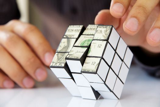 business man hand holding a rubik's cube,money concept