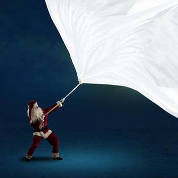 Santa Claus pulls a banner of cloth with a rope, place for text