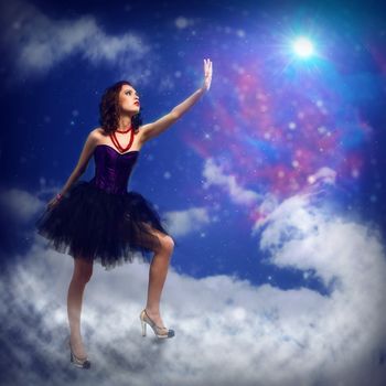 Young woman reaching for a glowing star, around abstract background