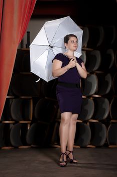 Female Actress in a purple dress with a white umbrella stand on the podium