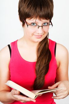 Young attractive girl with glasses holding an open book