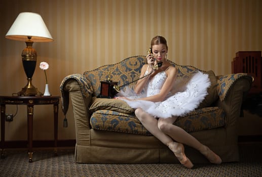 Professional ballet dancer talking on the phone in luxury interior