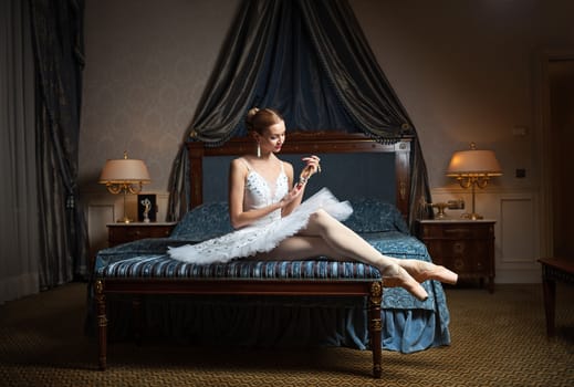 Ballet dancer in luxury bedroom and holding pearl necklace