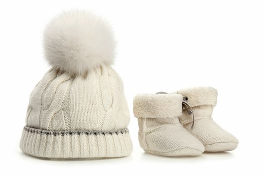 Warm woolen baby hat and booties over white background