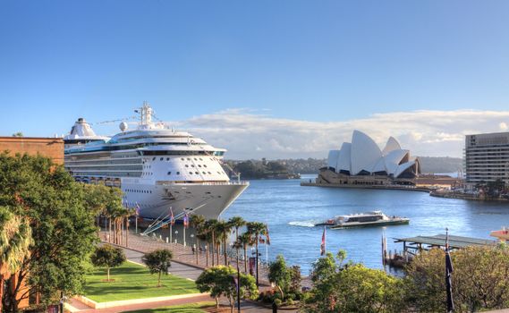 Sydney, Australia - December 1, 2013;  Royal Carribean Cruise Liner, Radiance of the Seas docked at Circular Quay in Sydney.   Sydney Opera House in background.  This ship boasts floor to ceiling windows and an outdoor cinema playing first run movies.  