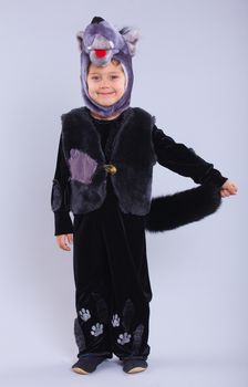 Little boy trying a carnival suit of wolf on the grey background