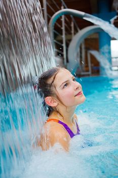 Activities on the pool. Cute girl swimming and playing in water in thermal hot pool