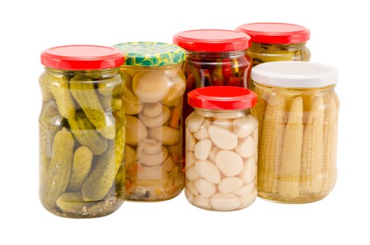 marinated preserved ecologic organic food vegetables mushrooms peppers cucumbers corns garlics in glass pots isolated on white background.