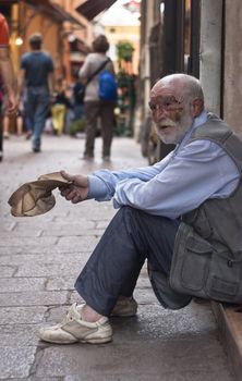 BOLOGNA - JUNE 2012- A homeless old man beggar sitting on the street and asking for help on  May 14, 2011 in BOLOGNA, Italy.