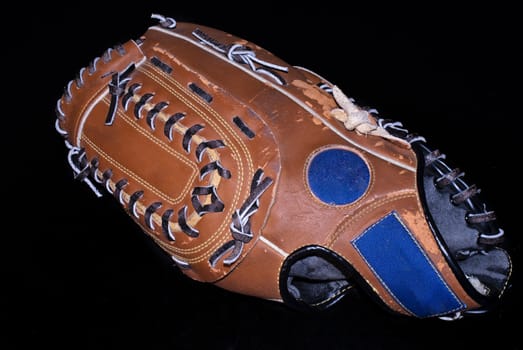 An antique baseball glove on black background 