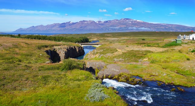 Beautiful landscape. Iceland. Mountain, river, forest, blue sky. Panorama