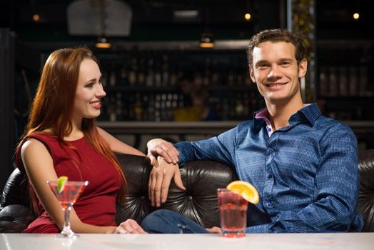 Young couple talking in a nightclub, have fun