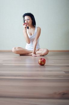 Serene lady sitting at home and eating fresh apples