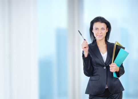 Successful businesswoman stands in office with documents and pen