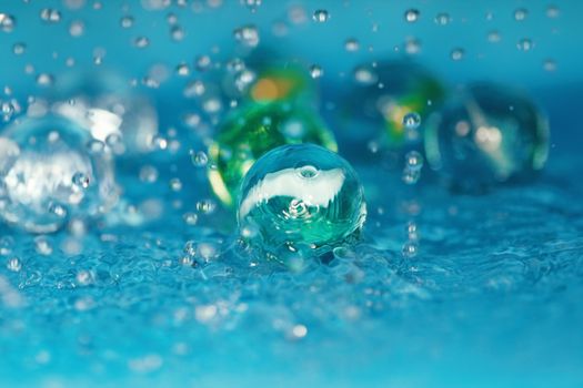 Extremely close-up macro photo of the glassy balls in the water. Shallow depth of field for natural view