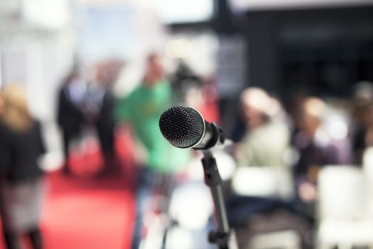 Microphone in focus against blurred audience