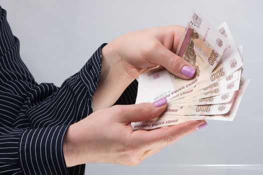 Well-groomed female hands with manicure hold banknotes Russian rubles
