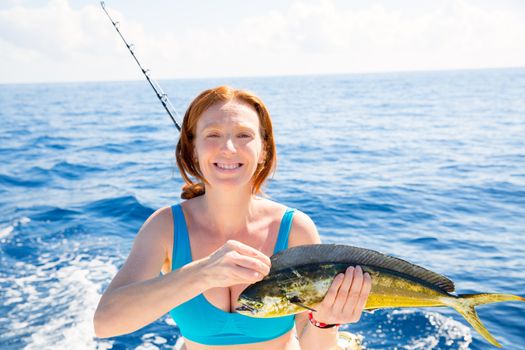 Woman fishing Dorado Mahi-mahi fish happy with trolling catch on boat deck