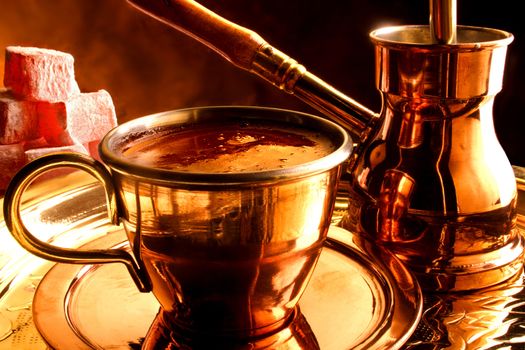 Cup of turkish coffee with pot on a tray, and traditional delicacy on the side.