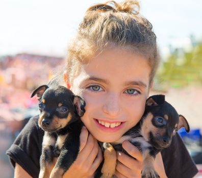 kid girl playing with puppy dogs smiling with blue eyes