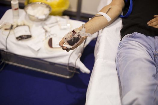 Blood donor's arm up close while giving blood