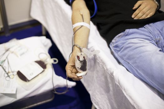 Blood donor's arm up close while giving blood