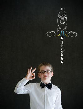 All ok or okay sign boy dressed up as business man with chalk success rocket on blackboard background