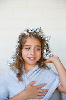 Funny kid girl scared about his dye hair with foil blue eyes